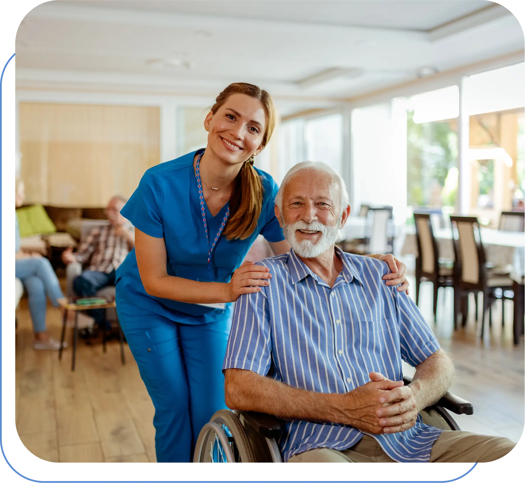 Nurse smiling with elderly man in wheelchair.