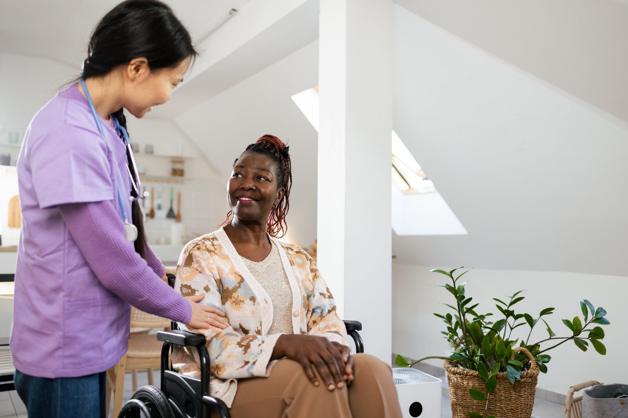 African American senior woman in a wheelchair having a visit from her home caregiver.